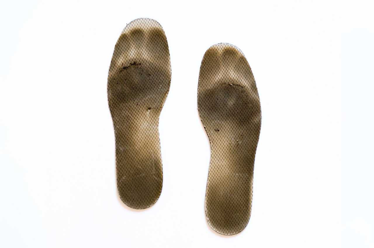 Närbild på smutsiga och slitna skoinlägg mot vit bakgrund. Bilden används av Nordic Rehab i en artikel om bakterier, svamp och hygien i skoinlägg, samt hur dåligt underhåll kan leda till lukt, fotsvamp och minskad stötdämpning.