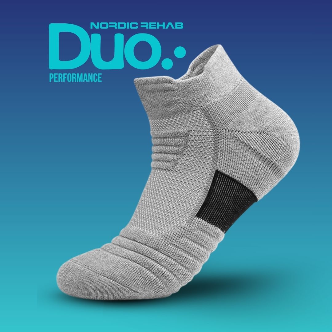 Nordic Rehab Duo Performance kompressionsstrumpa i grått med svart hälparti. Strumpan är andningsbar och har fem kompressionszoner som ger stöd, förbättrar cirkulationen och minskar svullnad vid aktivitet eller återhämtning.