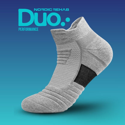 Nordic Rehab Duo Performance kompressionsstrumpa i grått med svart hälparti. Strumpan är andningsbar och har fem kompressionszoner som ger stöd, förbättrar cirkulationen och minskar svullnad vid aktivitet eller återhämtning.
