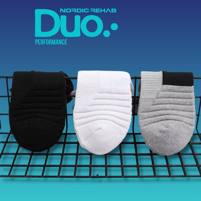 Nordic Rehab Duo Performance – 5 zoners kompressionsstrumpor i svart, vitt och grått. Bilden visar strumpornas strukturerade material och zonindelning för optimal andningsförmåga, kompression och komfort vid aktivitet eller återhämtning.