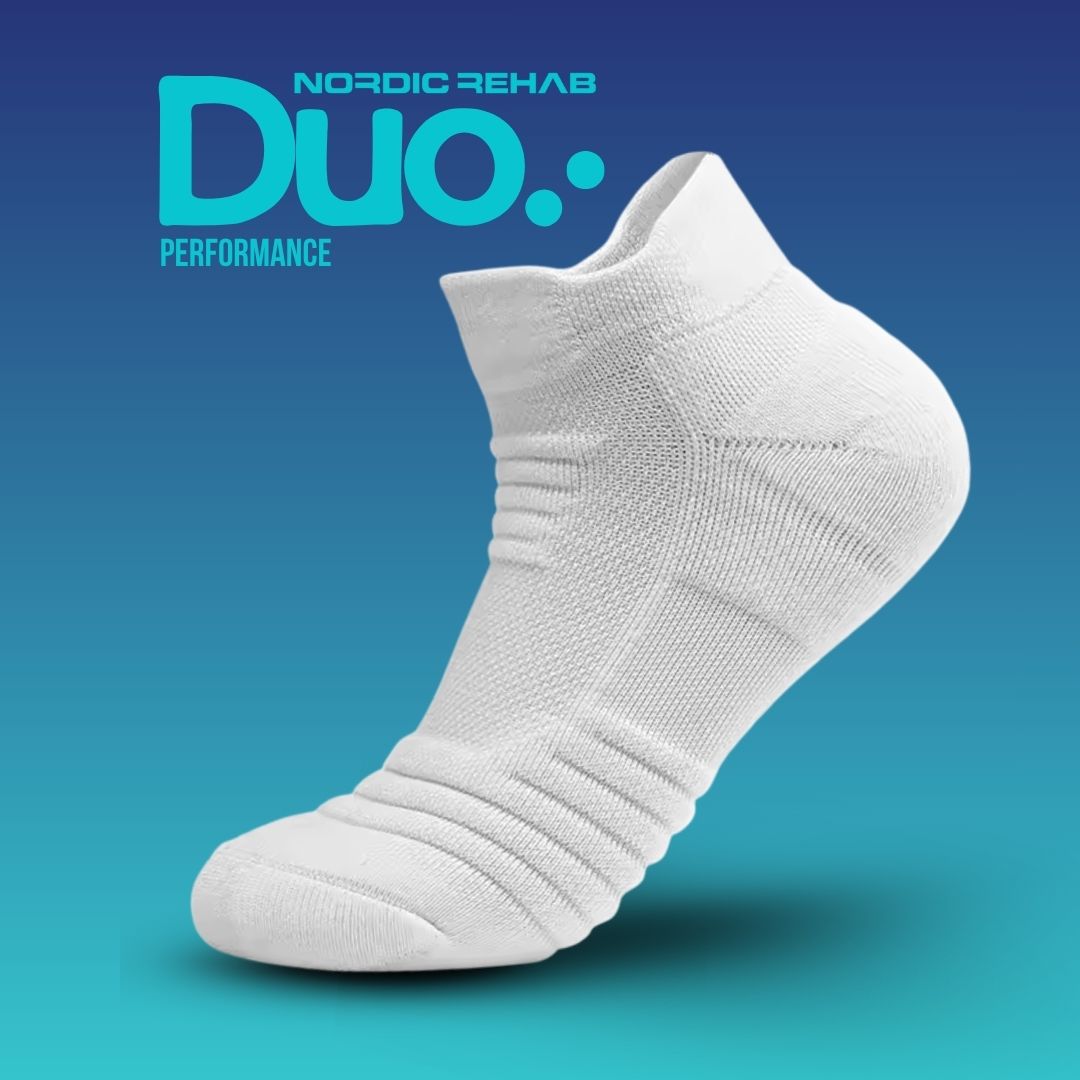 Produktbild på Nordic Rehab Duo Performance – 5 zoners kompressionsstrumpa i vitt. Strumpan har avancerad kompression för ökad blodcirkulation, stabilitet och återhämtning. Designad för att minska trötthet i fötter och ge komfort vid både träning och vardag.