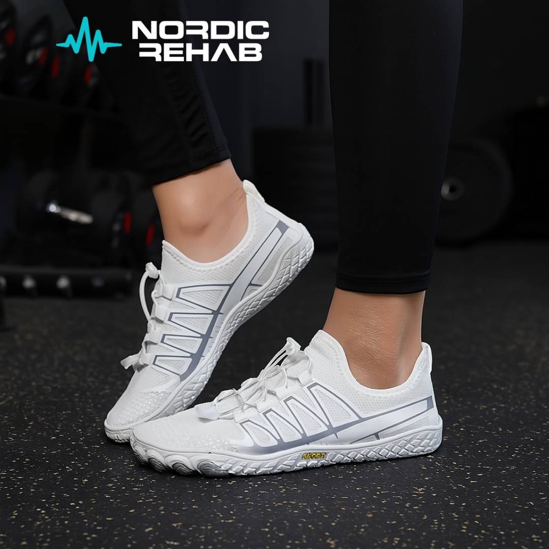 Bild från Nordic Rehab som visar en person på gymmet iförd vita NEO Sport barfotaskor. Skorna har tunn flexibel sula och gott tåutrymme som stärker fotmuskulaturen, ger naturlig rörelse och stabilitet. Perfekta för gymträning och lyft där markkontakt och balans från grunden är avgörande.