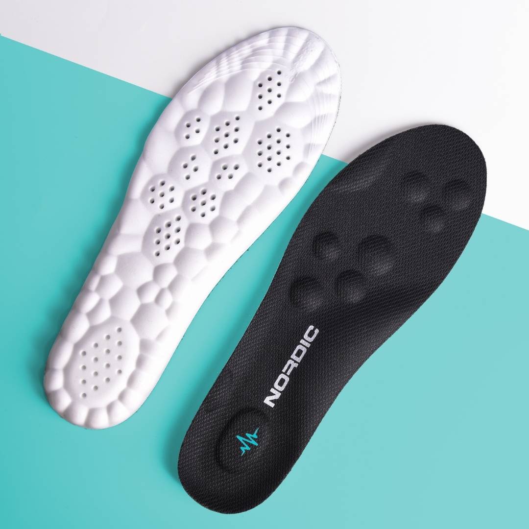 Produktbild från Nordic Rehab som visar CloudTech Comfort-skoinlägg med ovansida i svart och undersida i vit dämpande sula. Bilden visar ventilationshål, mjukt fotvalvsstöd och rundade massagepunkter för hög komfort och stabilitet.